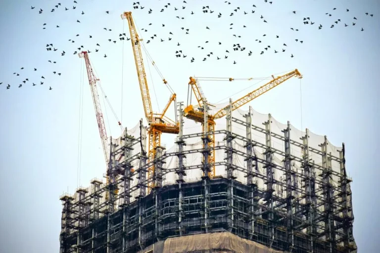 High-rise building under construction ringed by tower cranes