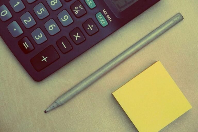 Calculator, pencil and notes laid out on a desk