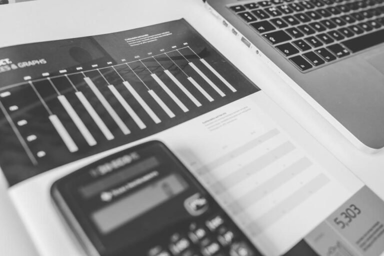 Printed financial spreadsheet beside a calculator