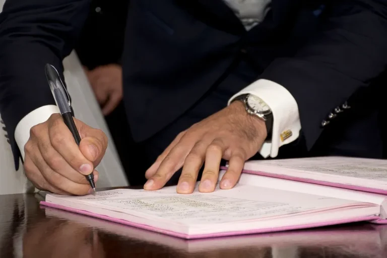 Signing a formal contract document at a desk