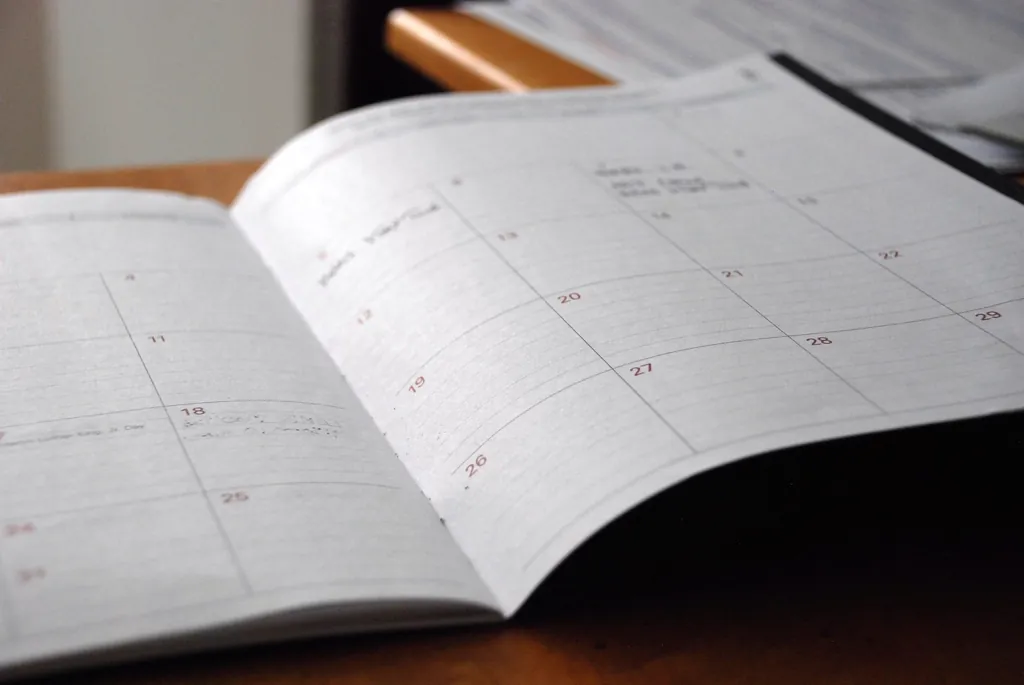 Open monthly calendar and notes on a desk